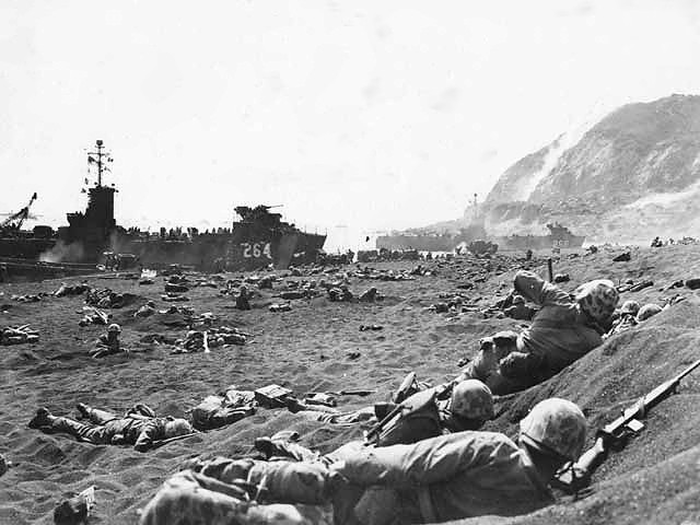 Marines burrow in the volcanic sand, on the beach of Iwo Jima.